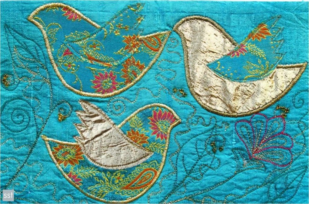 Example of advanced skill stage 4 patchwork and quilting piece featuring turquoise floral birds, outlined in gold