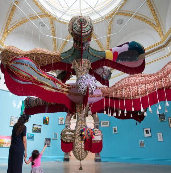Installation view of the 250th Summer Exhibition at the Royal Academy, featuring a large suspended bird-like figure made from textiles