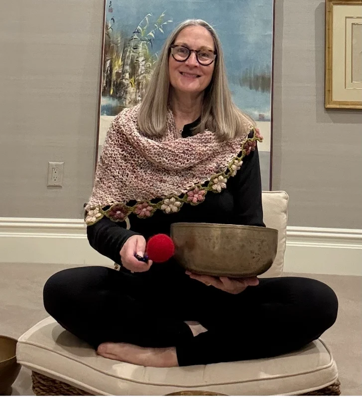 Mary Ann Gebhardt with a hand knitted shawl and sound bowl